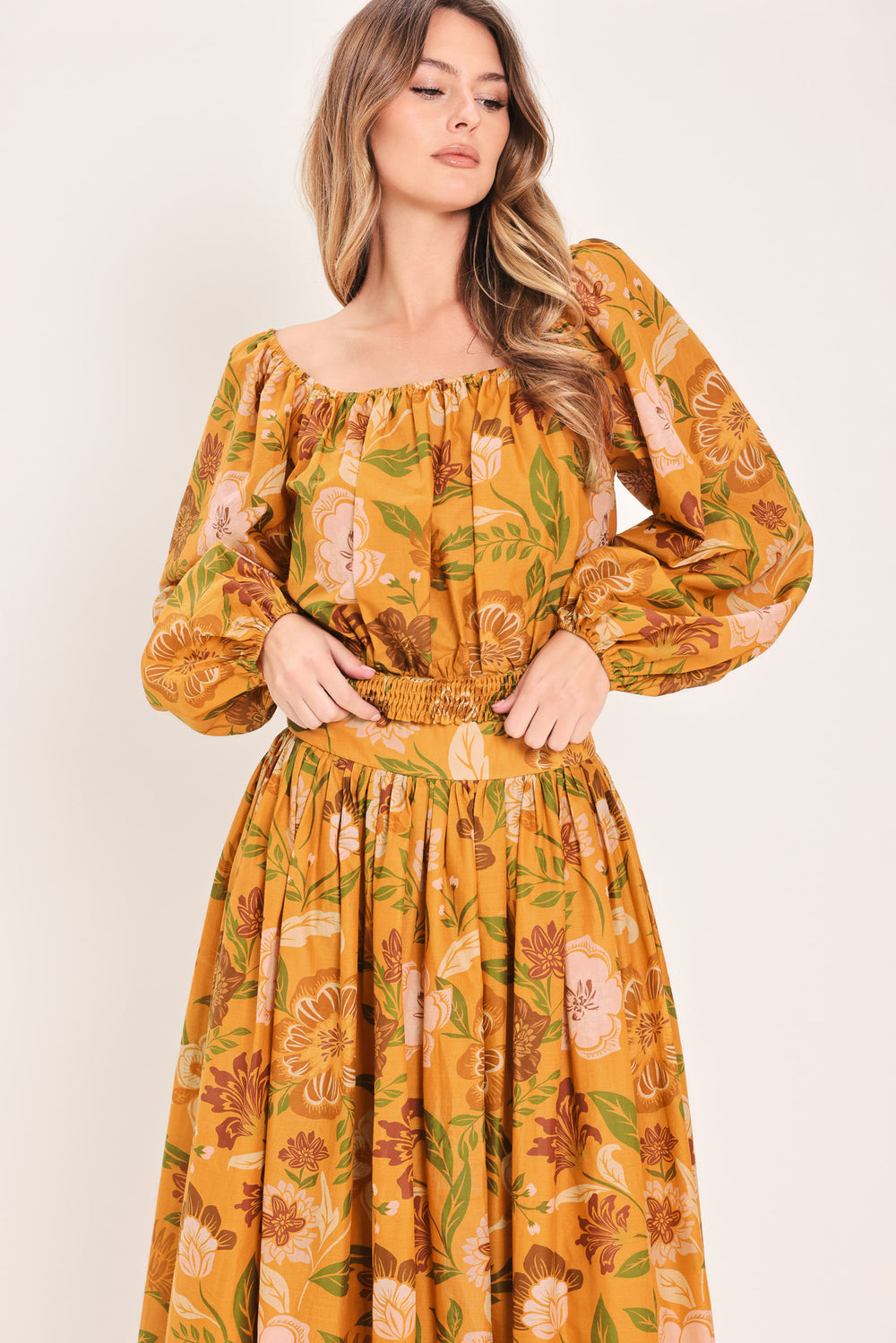 Woman wearing a mustard yellow floral patterned midi skirt | Flying Tomato