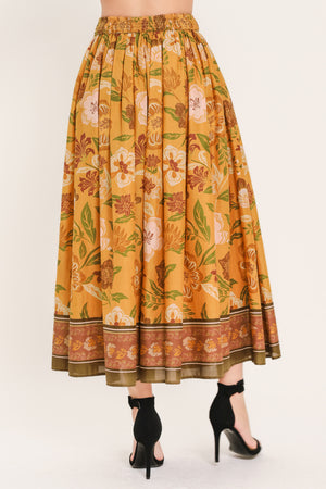 Woman wearing a mustard yellow floral patterned midi skirt | Flying Tomato