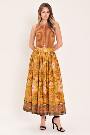 Woman wearing a mustard yellow floral patterned midi skirt | Flying Tomato