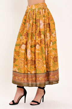 Woman wearing a mustard yellow floral patterned midi skirt | Flying Tomato