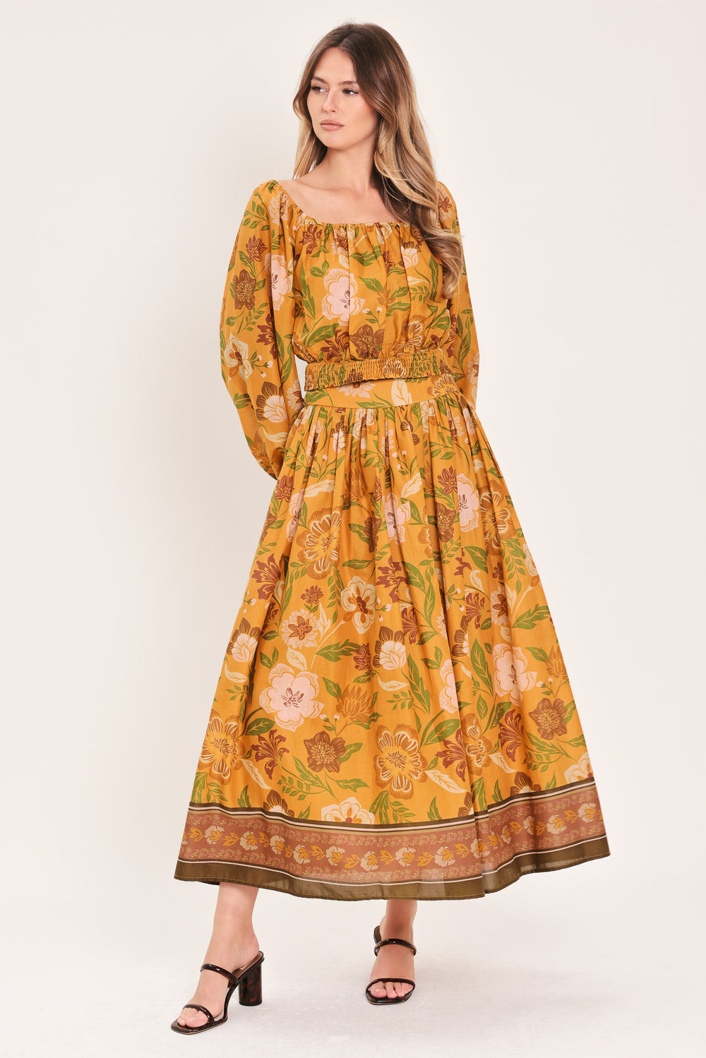 Woman wearing a mustard yellow floral patterned midi skirt | Flying Tomato