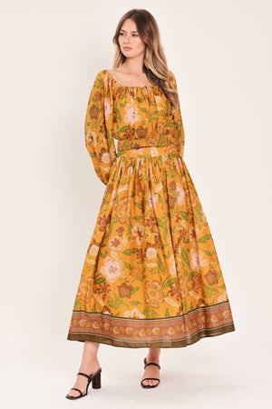 Woman wearing a mustard yellow floral patterned midi skirt | Flying Tomato