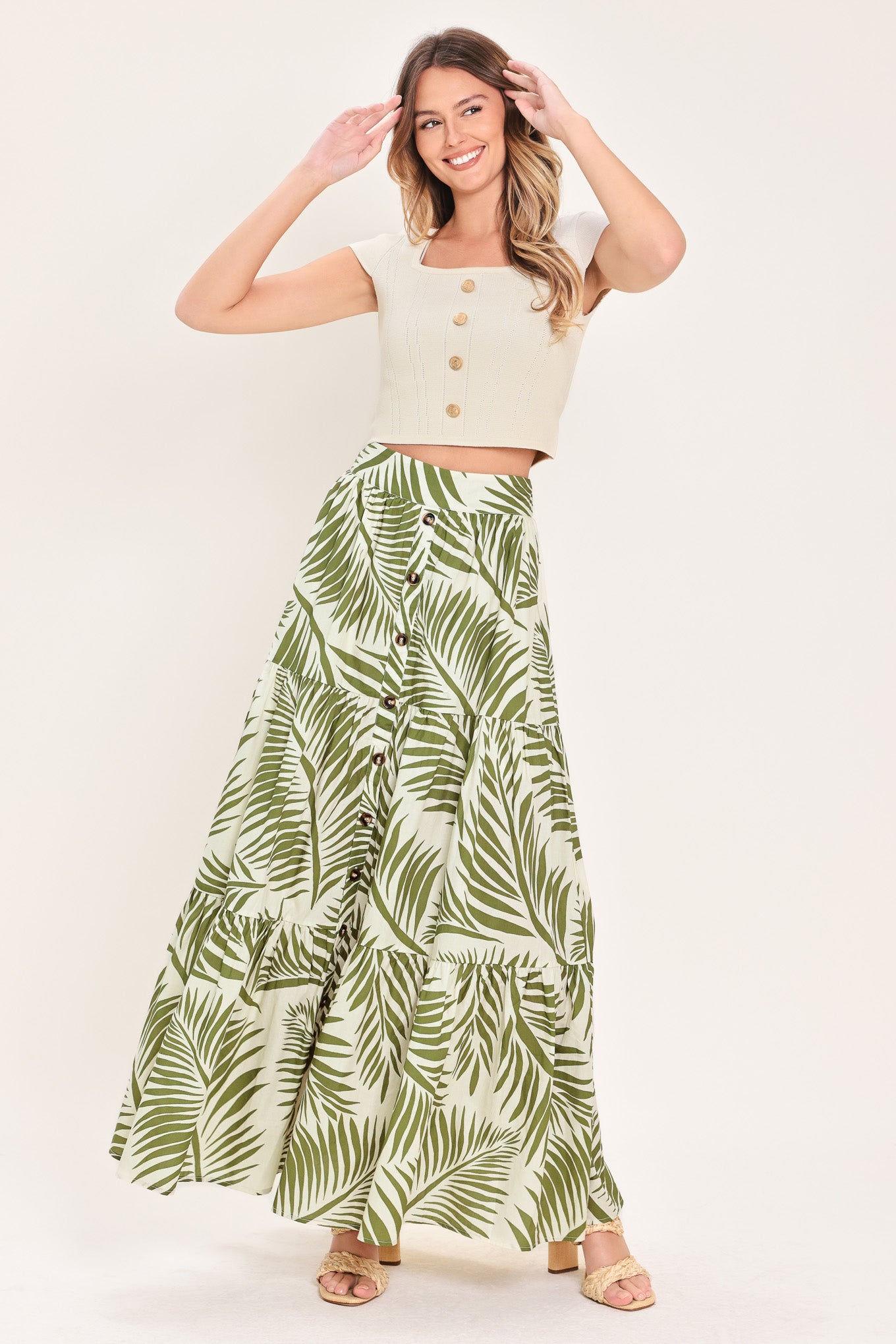 Woman wearing a green leaf-patterned maxi skirt featuring front button down, tiers and smocked back waistband | Flying Tomato