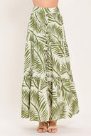 Woman wearing a green leaf-patterned maxi skirt featuring front button down, tiers and smocked back waistband | Flying Tomato