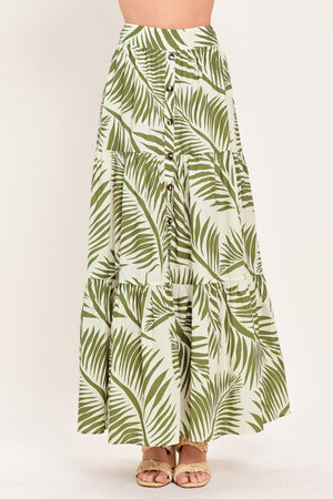 Woman wearing a green leaf-patterned maxi skirt featuring front button down, tiers and smocked back waistband | Flying Tomato