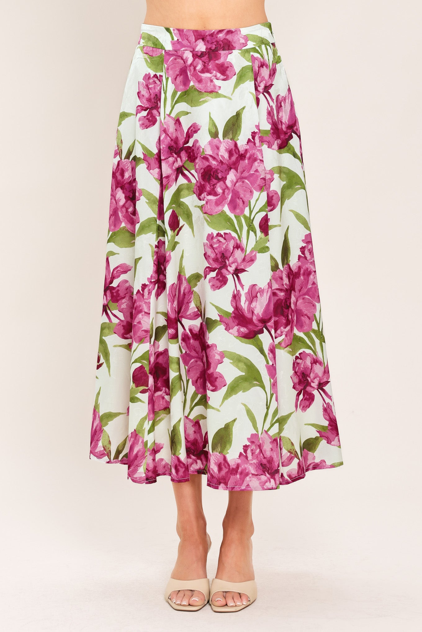 A high-waisted, A-line midi skirt with a vibrant pink and green floral print on a white background | Flying Tomato