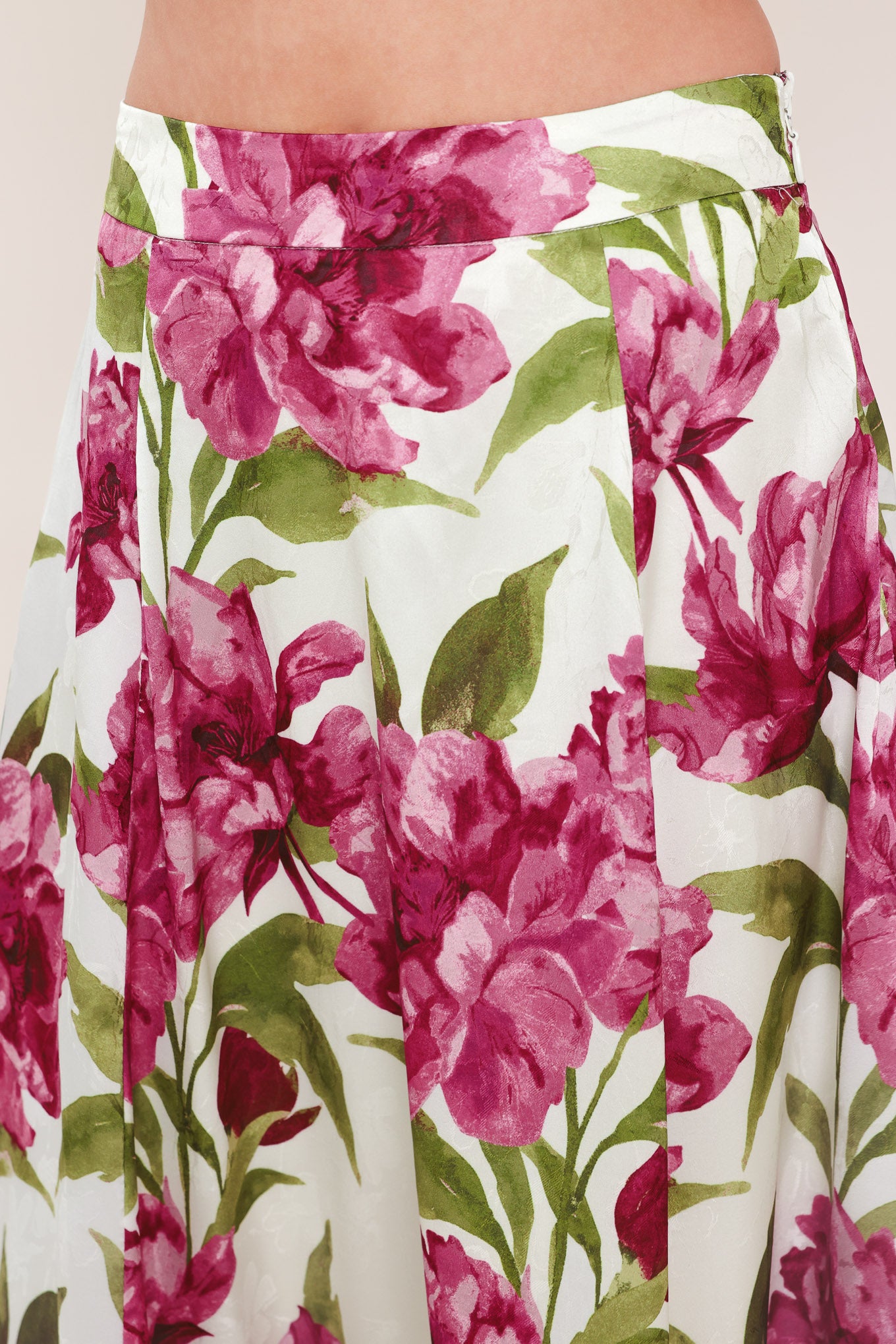 A high-waisted, A-line midi skirt with a vibrant pink and green floral print on a white background | Flying Tomato