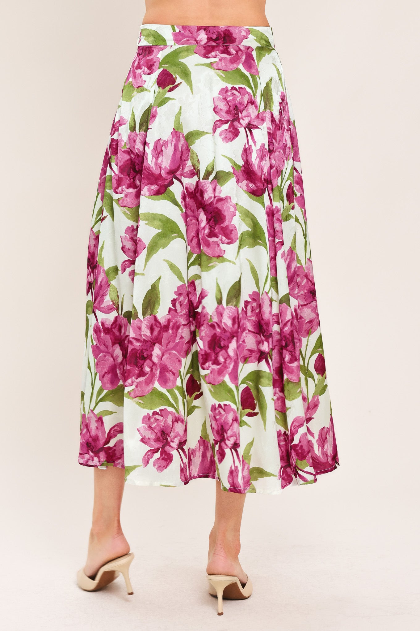 A high-waisted, A-line midi skirt with a vibrant pink and green floral print on a white background | Flying Tomato