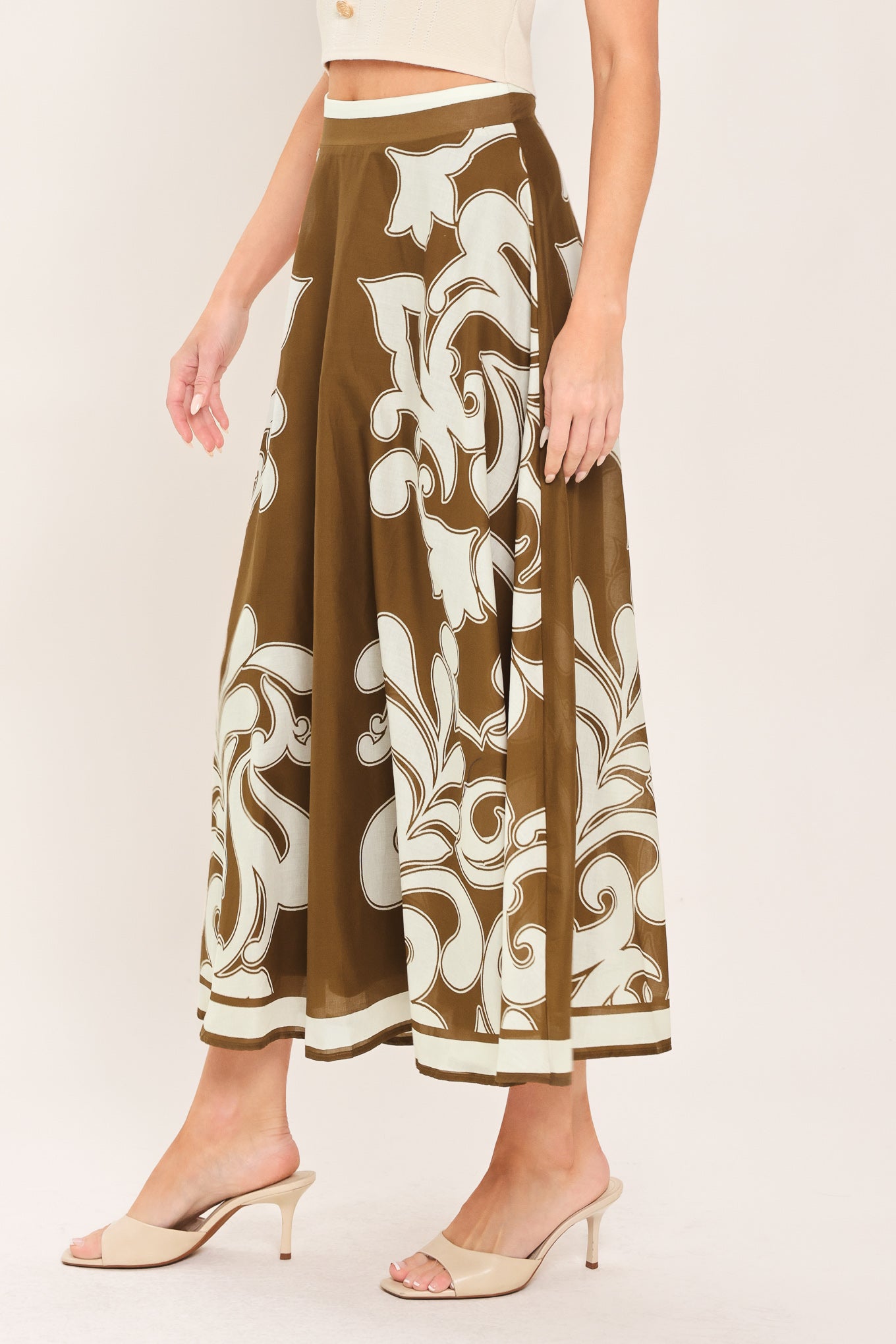 A woman wearing a brown midi skirt with a large white baroque pattern | Flying Tomato