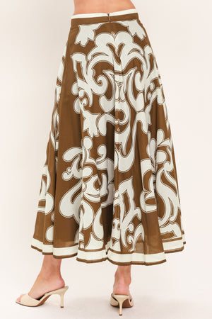 A woman wearing a brown midi skirt with a large white baroque pattern | Flying Tomato