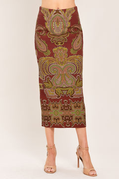 A woman wearing a midi skirt with an ornate paisley pattern in rust red, gold, and olive green | Flying Tomato