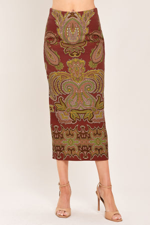 A woman wearing a midi skirt with an ornate paisley pattern in rust red, gold, and olive green | Flying Tomato