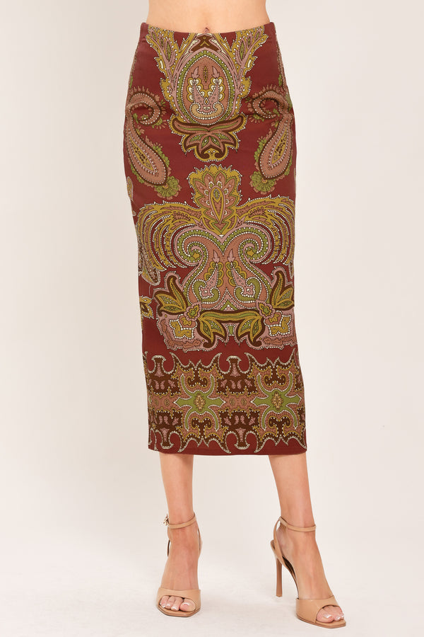 A woman wearing a midi skirt with an ornate paisley pattern in rust red, gold, and olive green | Flying Tomato