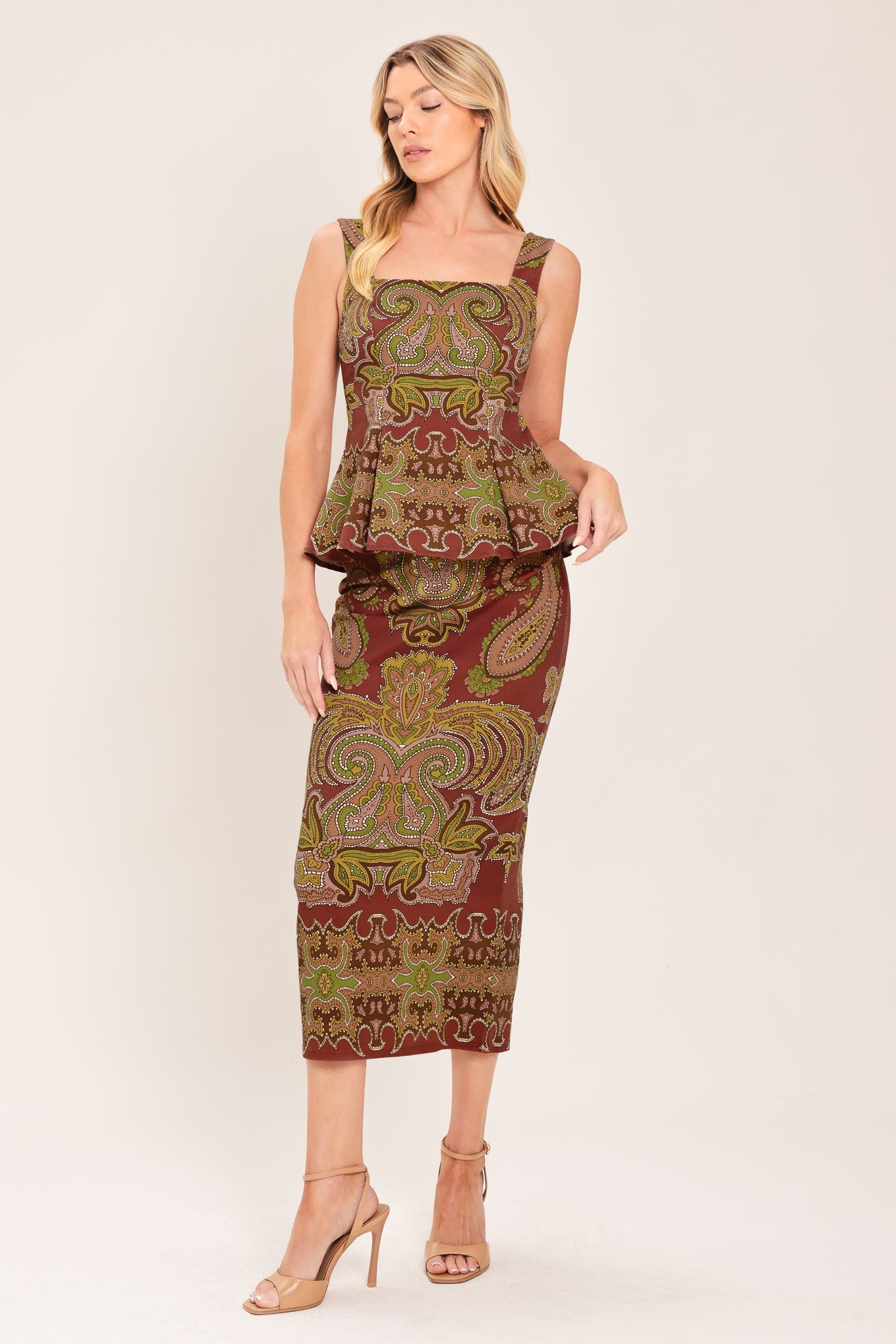 A woman wearing a midi skirt with an ornate paisley pattern in rust red, gold, and olive green | Flying Tomato
