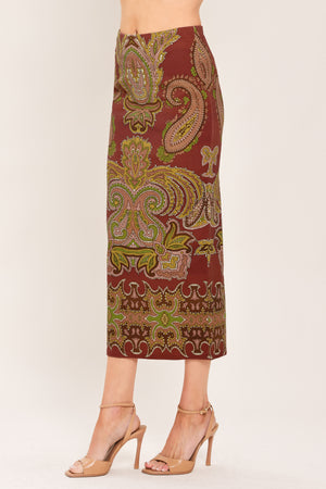 A woman wearing a midi skirt with an ornate paisley pattern in rust red, gold, and olive green | Flying Tomato