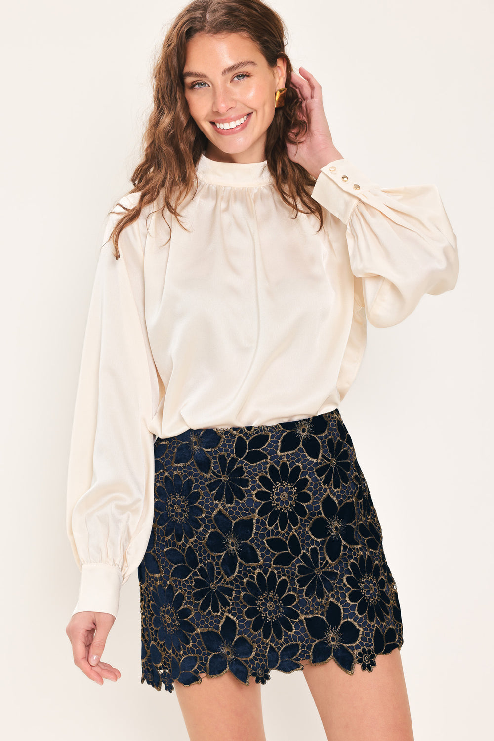 Woman wearing a navy blue velvet high-waisted mini skirt with gold floral lace over | Flying Tomato
