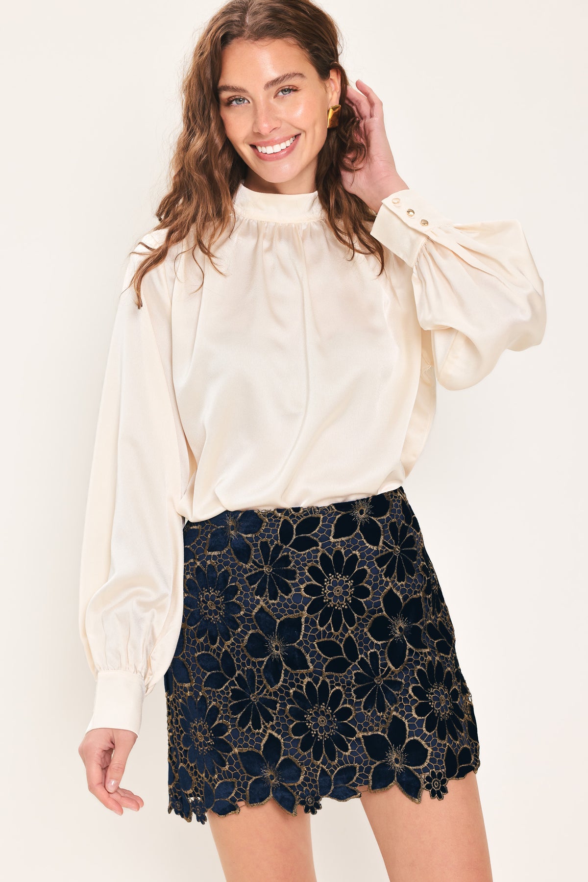 Woman wearing a navy blue velvet high-waisted mini skirt with gold floral lace over | Flying Tomato