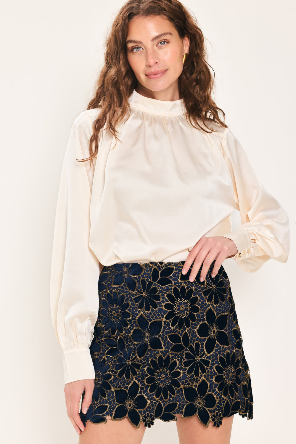 Woman wearing a navy blue velvet high-waisted mini skirt with gold floral lace over | Flying Tomato