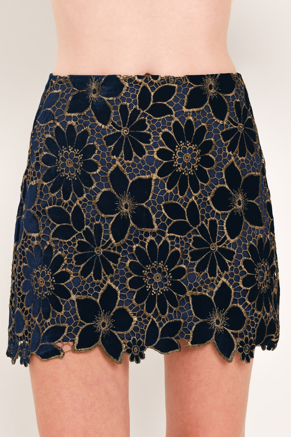 Woman wearing a navy blue velvet high-waisted mini skirt with gold floral lace over | Flying Tomato