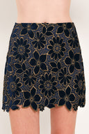 Woman wearing a navy blue velvet high-waisted mini skirt with gold floral lace over | Flying Tomato