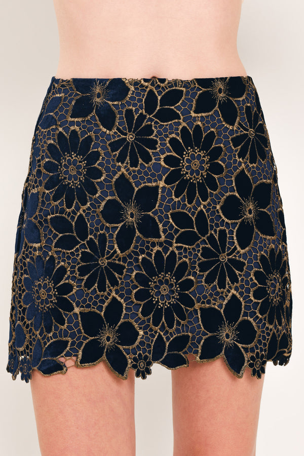 Woman wearing a navy blue velvet high-waisted mini skirt with gold floral lace over | Flying Tomato