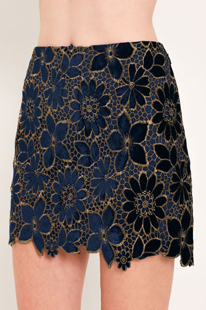Woman wearing a navy blue velvet high-waisted mini skirt with gold floral lace over | Flying Tomato