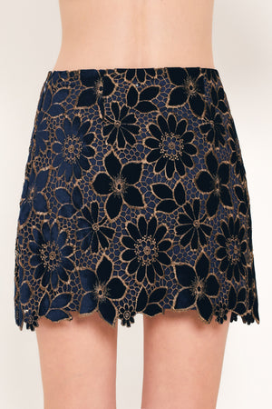 Woman wearing a navy blue velvet high-waisted mini skirt with gold floral lace over | Flying Tomato