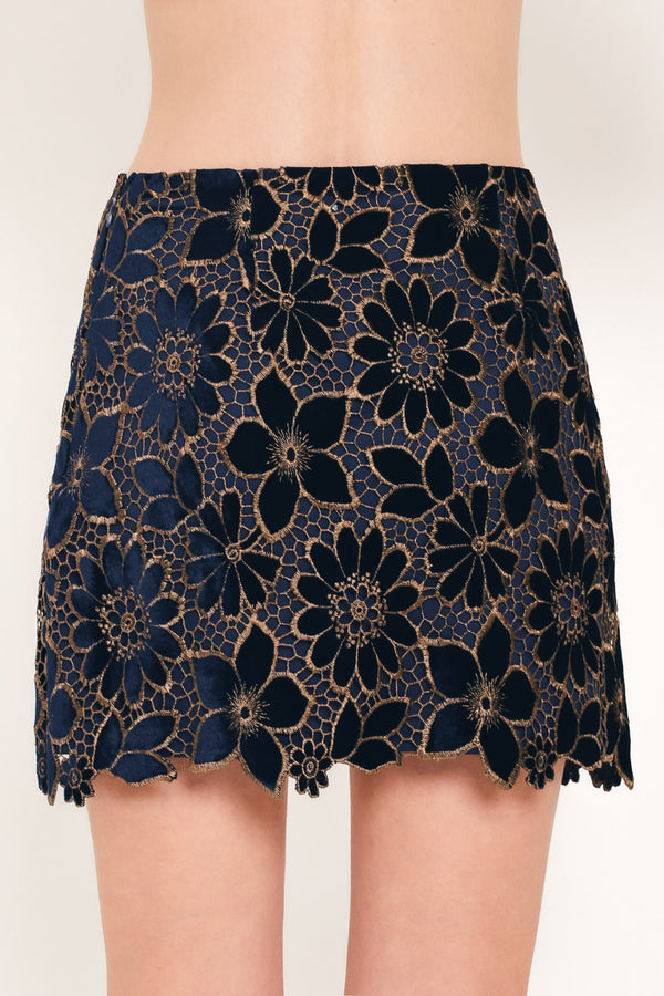 Woman wearing a navy blue velvet high-waisted mini skirt with gold floral lace over | Flying Tomato