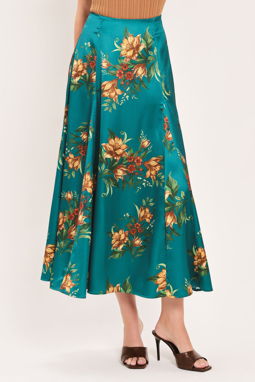A woman wearing a teal green midi skirt with a vibrant orange and yellow floral print | Flying Tomato