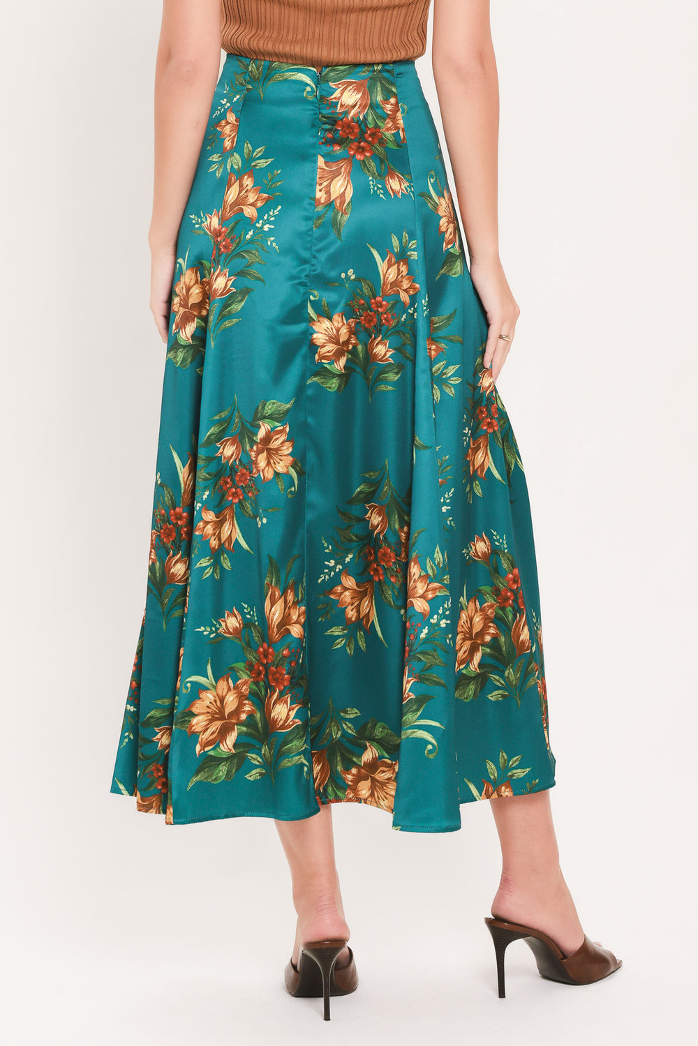 A woman wearing a teal green midi skirt with a vibrant orange and yellow floral print | Flying Tomato