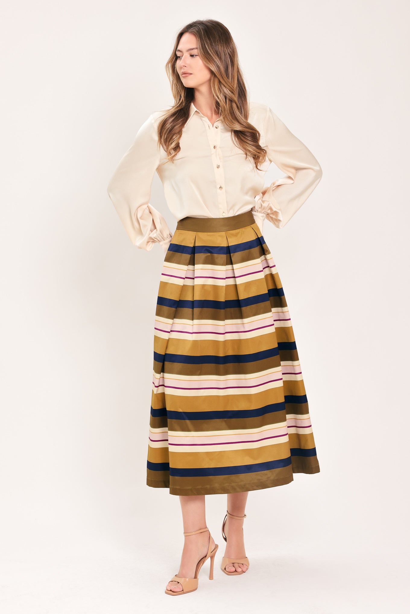 Woman wearing a multicolored beige, mustard yellow, navy blue, and burgundy striped midi skirt with pleats and pockets | Flying Tomato