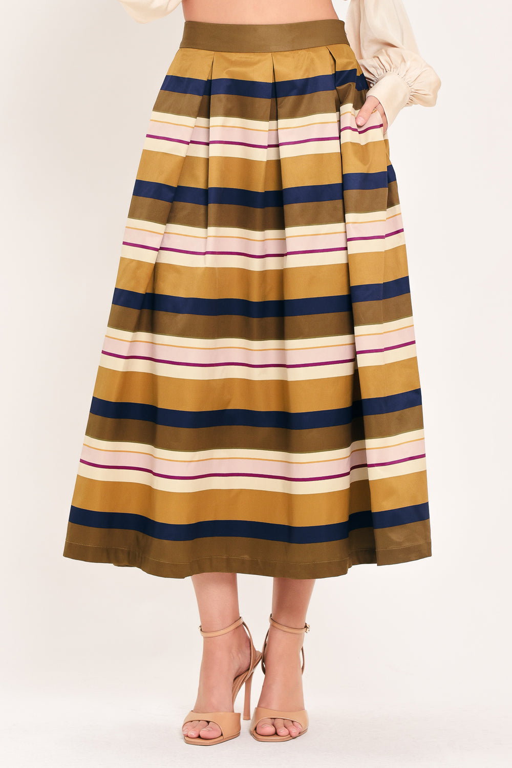 Woman wearing a multicolored beige, mustard yellow, navy blue, and burgundy striped midi skirt with pleats and pockets | Flying Tomato