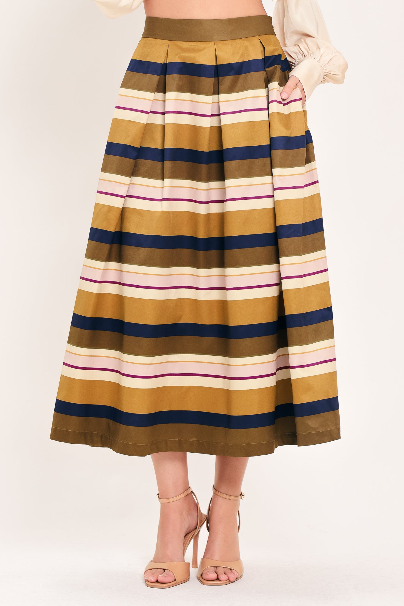 Woman wearing a multicolored beige, mustard yellow, navy blue, and burgundy striped midi skirt with pleats and pockets | Flying Tomato