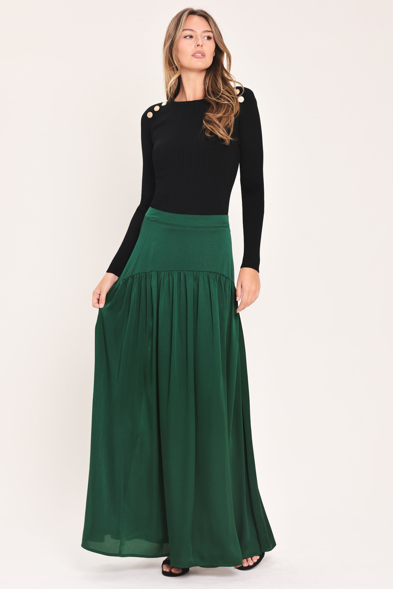 A dark hunter green satin-like maxi skirt with a drop waist worn by a model | Flying Tomato