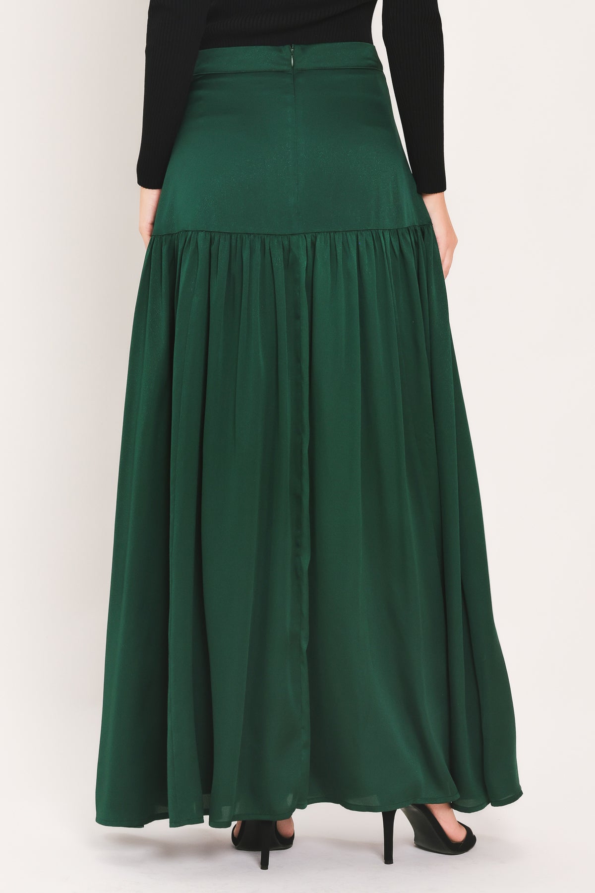 A dark hunter green satin-like maxi skirt with a drop waist worn by a model | Flying Tomato