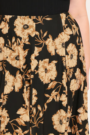 A woman modeling a sleeveless black top paired with a long black skirt featuring a large beige floral print | Plus Curve Flying Tomato
