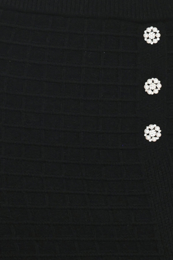 A black textured midi skirt with a front slit and three decorative silver buttons, worn by a model | Flying Tomato