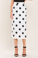 A woman wearing a white midi pencil skirt with large black polka dots | Flying Tomato