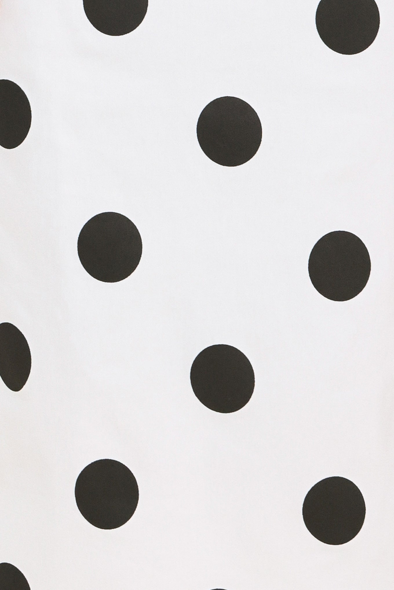 A woman wearing a white midi pencil skirt with large black polka dots | Flying Tomato