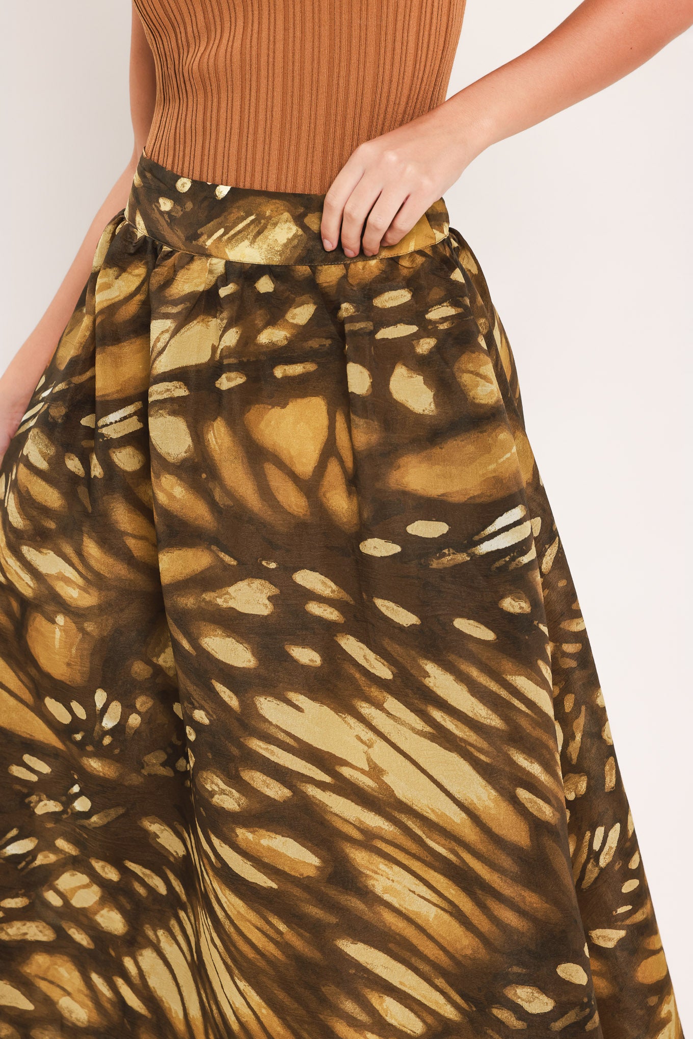 A woman wearing a dark brown maxi skirt with a butterfly-like pattern | Flying Tomato