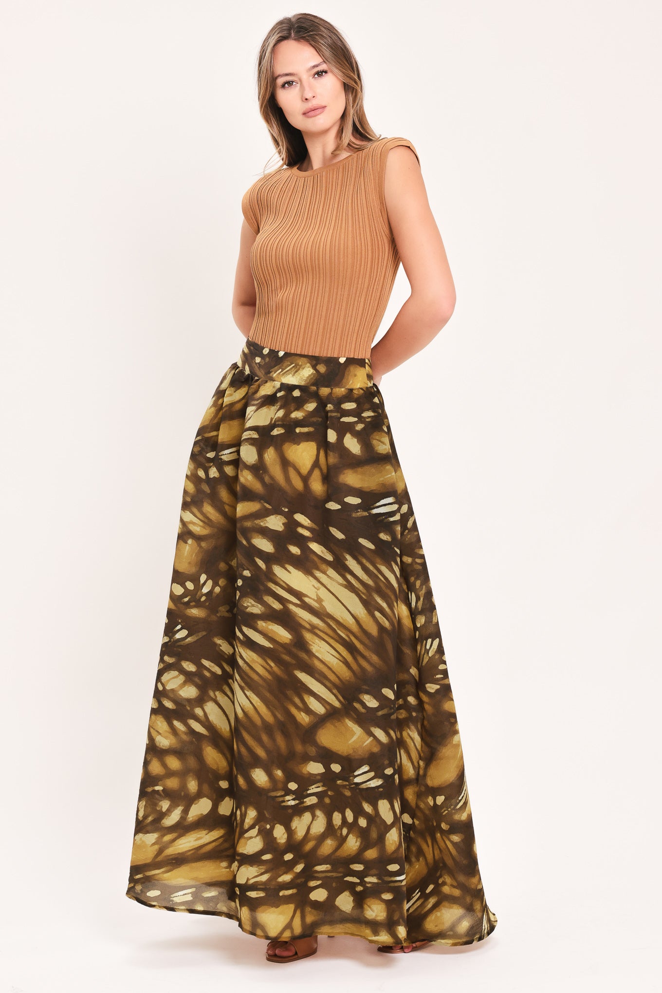 A woman wearing a dark brown maxi skirt with a butterfly-like pattern | Flying Tomato