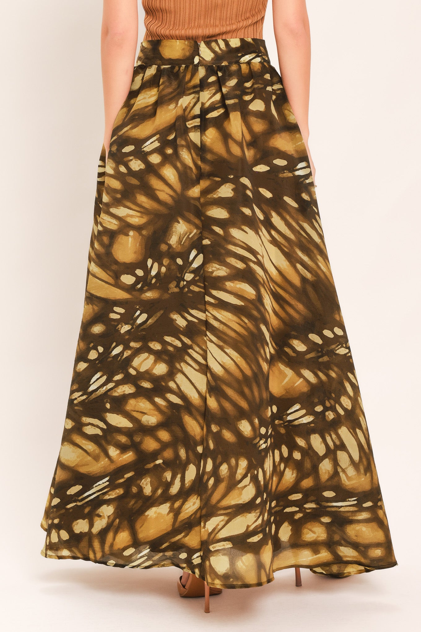 A woman wearing a dark brown maxi skirt with a butterfly-like pattern | Flying Tomato