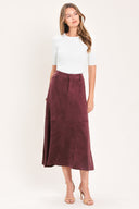 A woman modeling a high-waisted, midi A-line skirt in a deep burgundy suede-like fabric | Flying Tomato