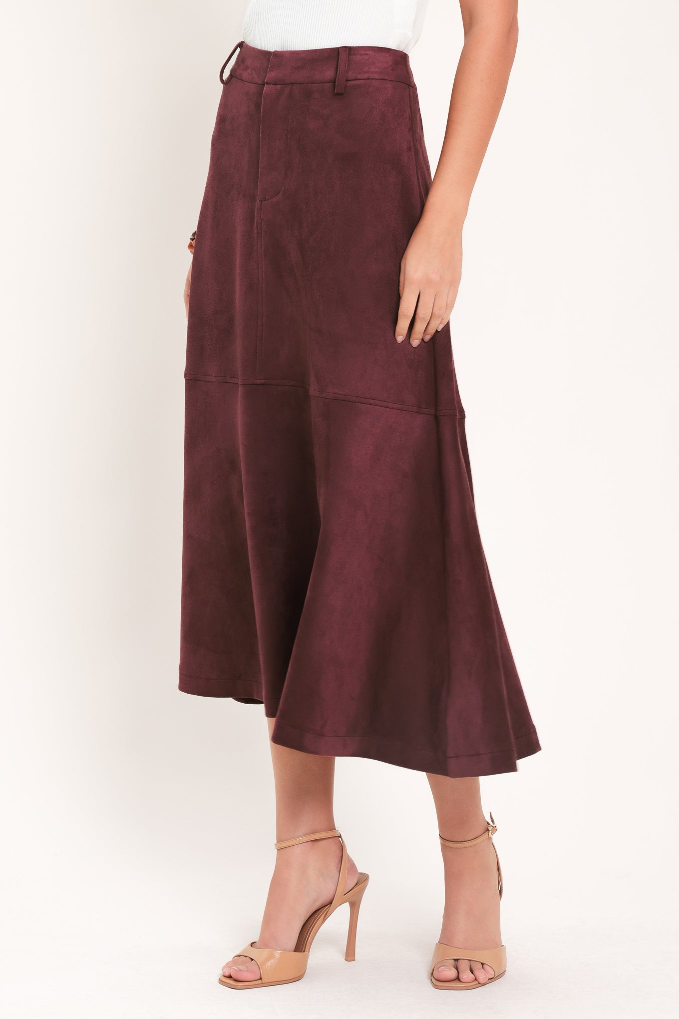 A woman modeling a high-waisted, midi A-line skirt in a deep burgundy suede-like fabric | Flying Tomato