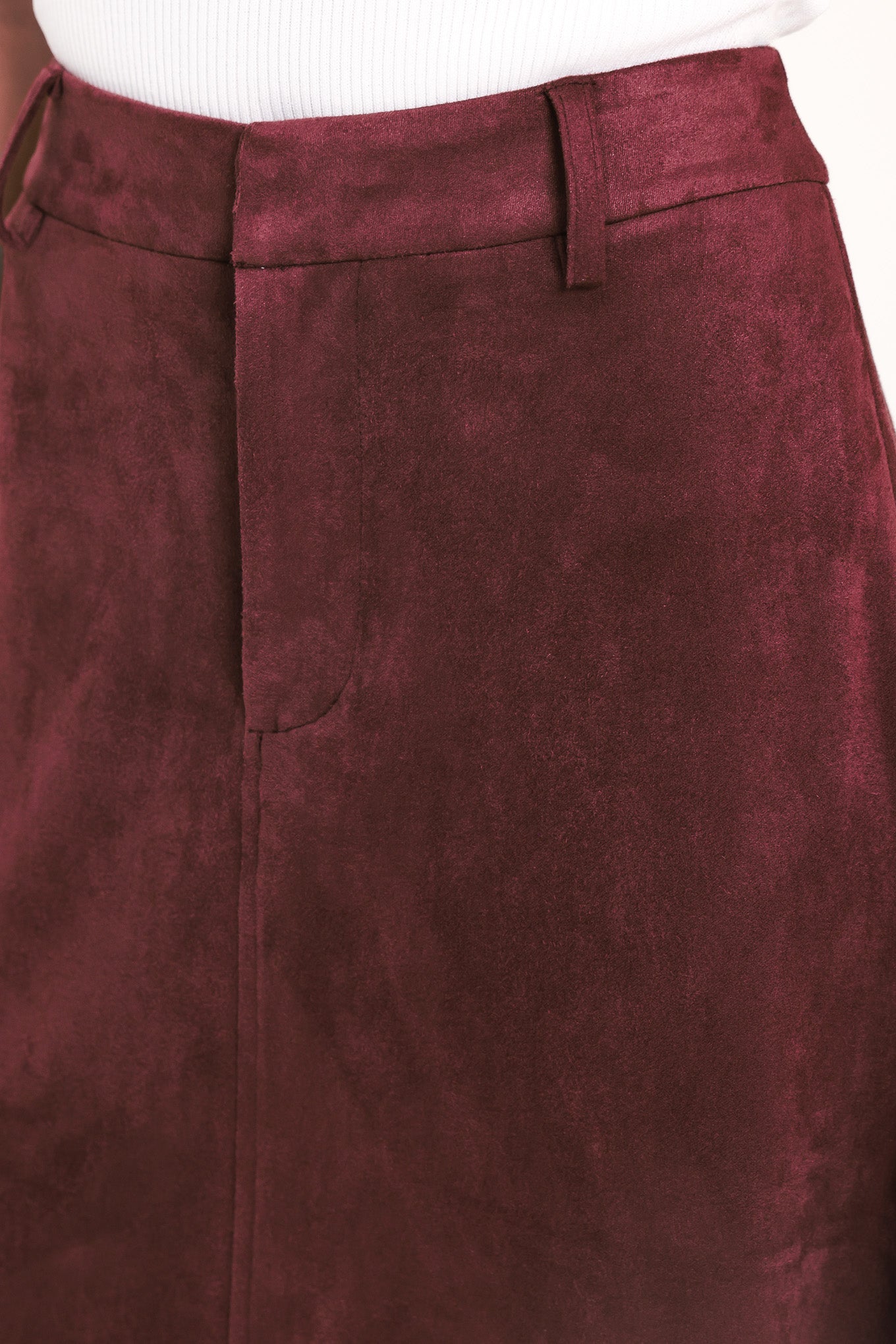 A woman modeling a high-waisted, midi A-line skirt in a deep burgundy suede-like fabric | Flying Tomato