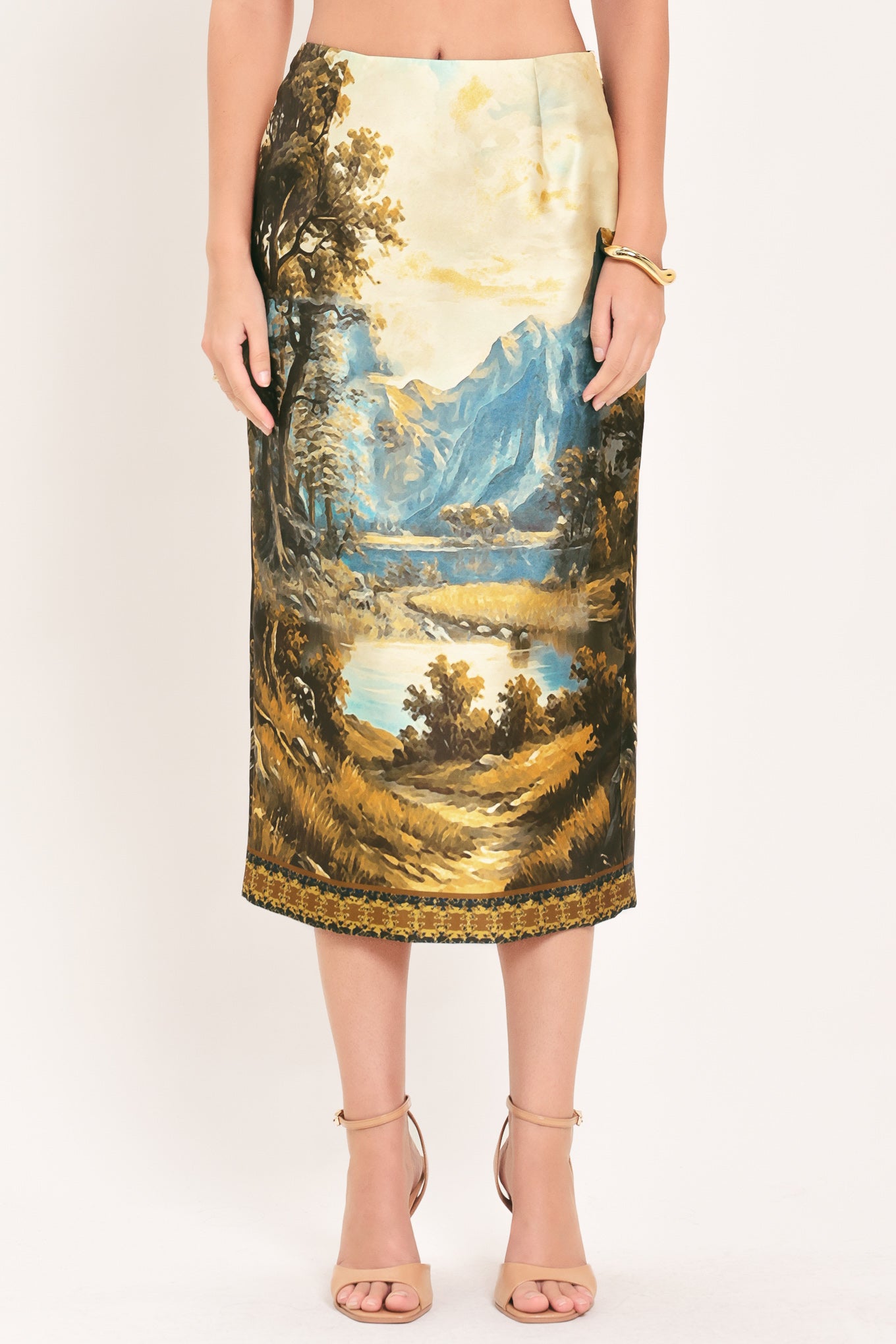 A model wearing a high-waisted midi skirt with a detailed landscape print of mountains, lakes, and trees | Flying Tomato