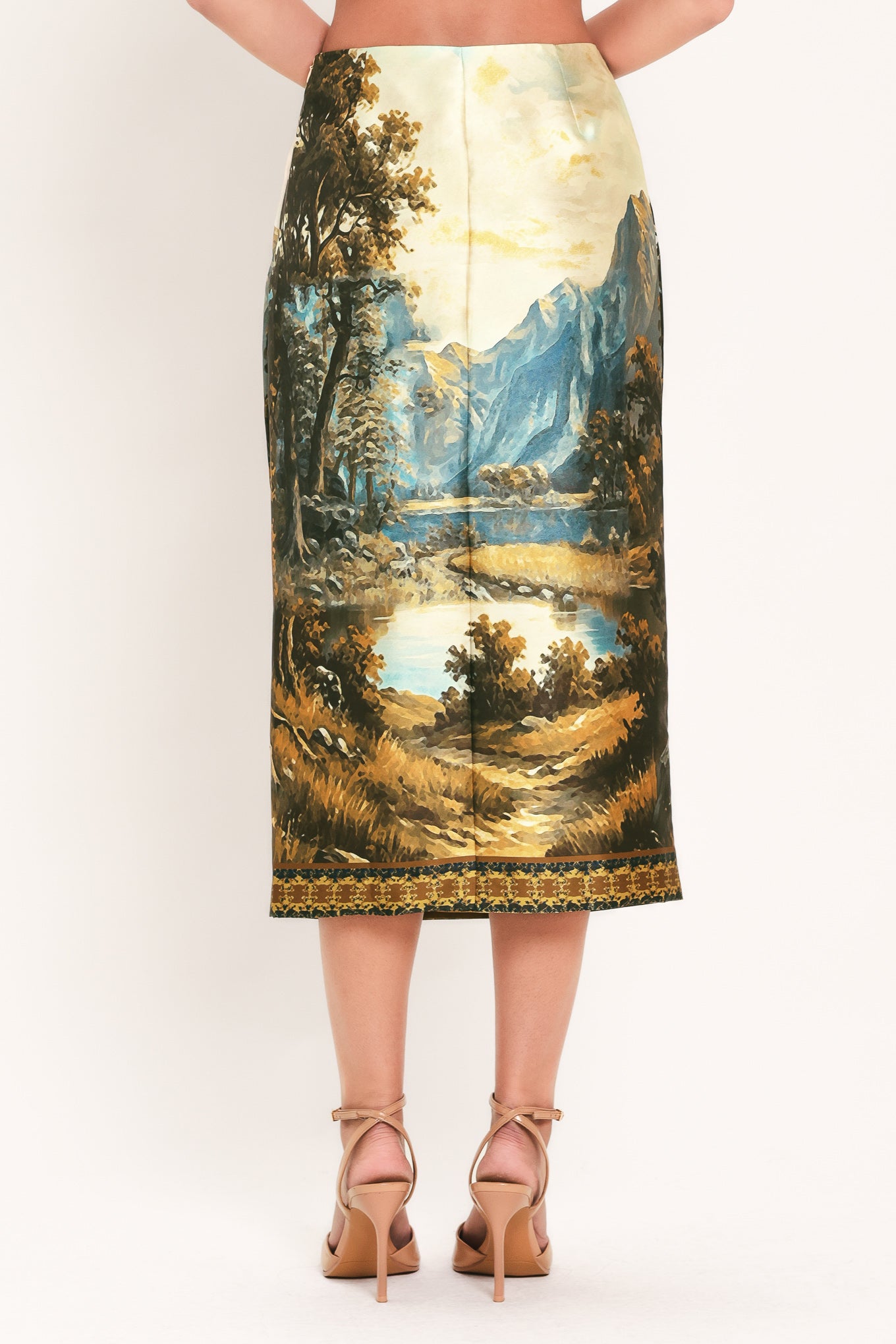 A model wearing a high-waisted midi skirt with a detailed landscape print of mountains, lakes, and trees | Flying Tomato