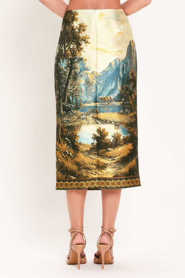 A model wearing a high-waisted midi skirt with a detailed landscape print of mountains, lakes, and trees | Flying Tomato