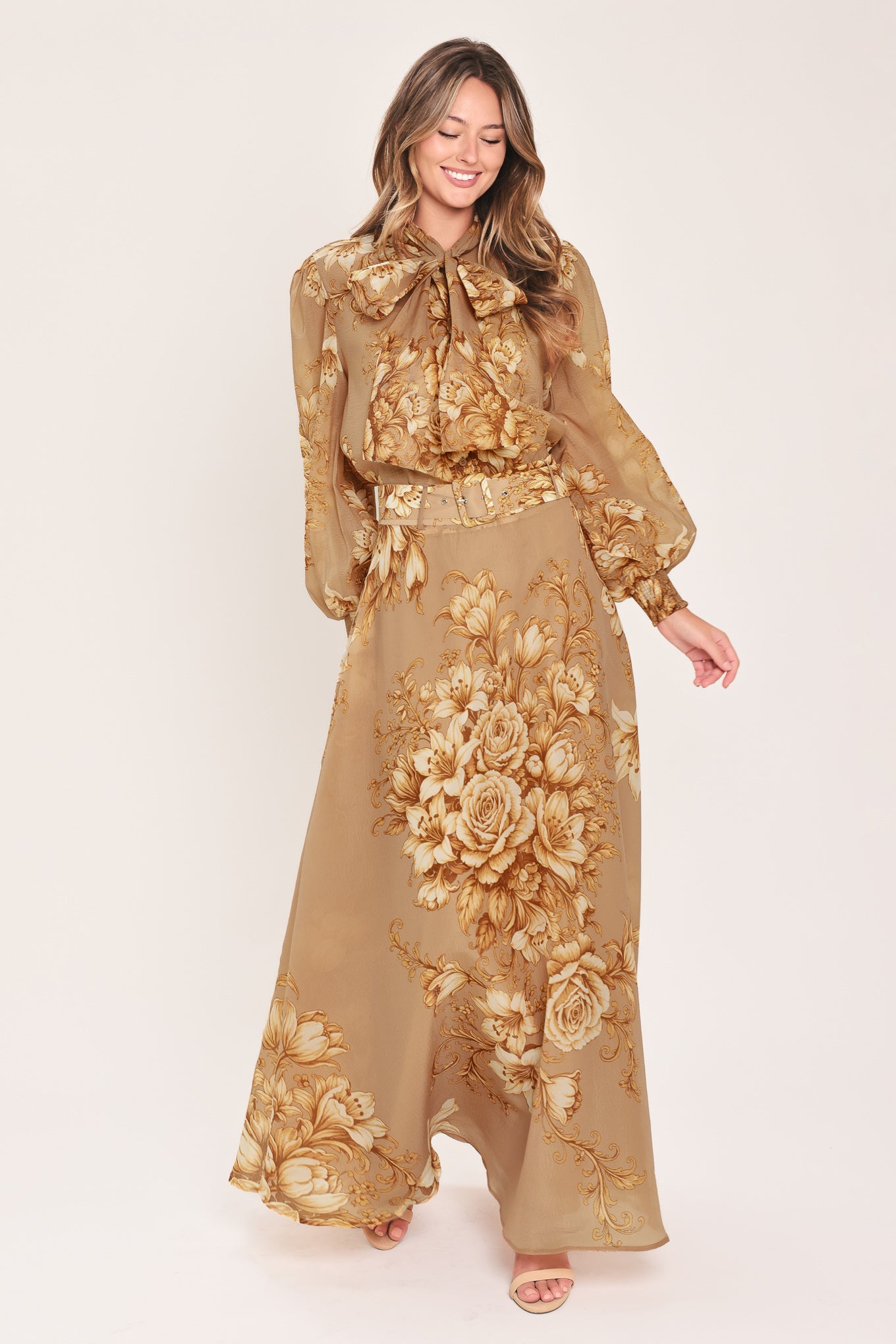 A floor-length beige skirt with a large gold and cream floral rose pattern, featuring a matching beaded belt, shown on a model | Flying Tomato