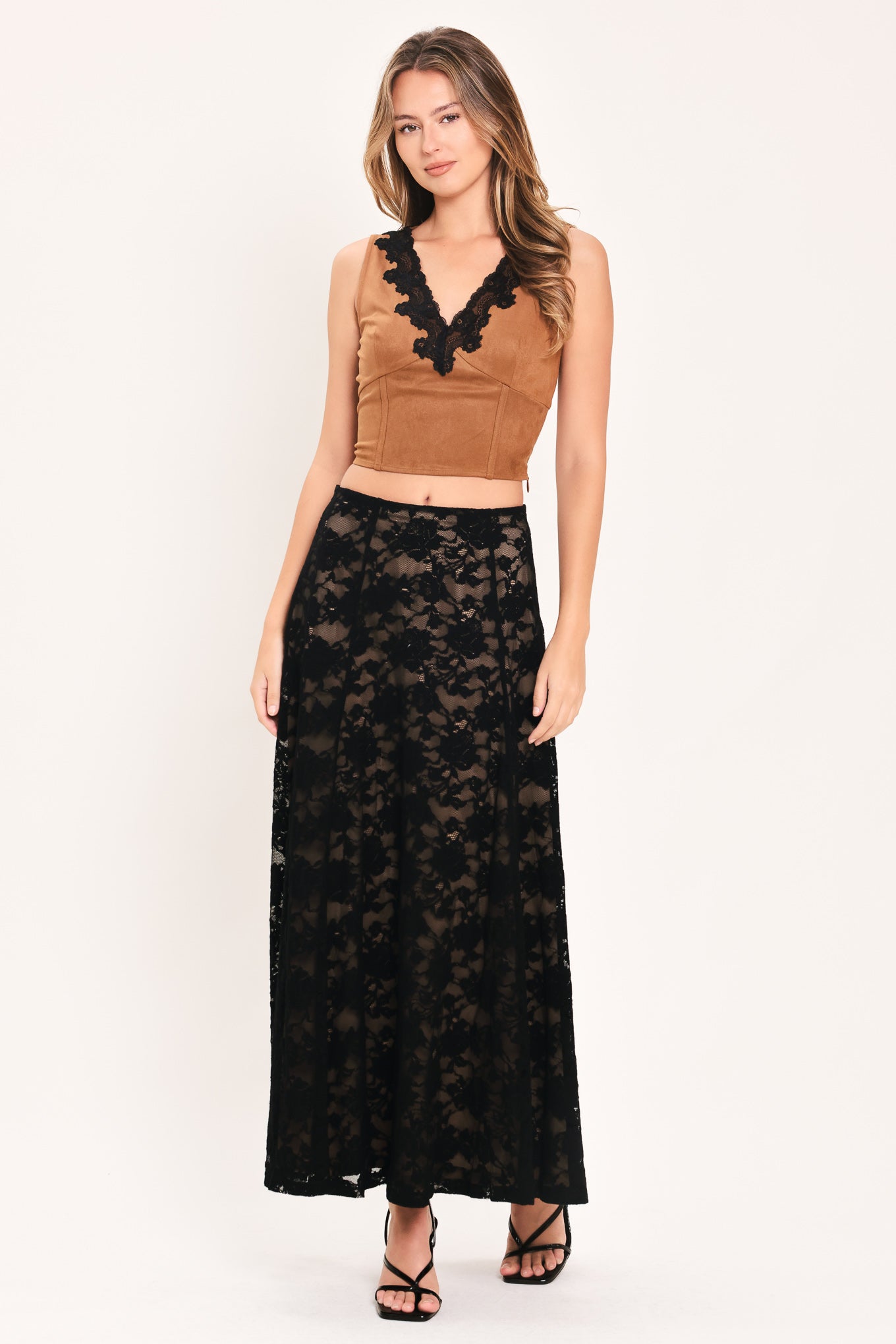 Woman wearing a long black lace skirt with a nude base | Flying Tomato